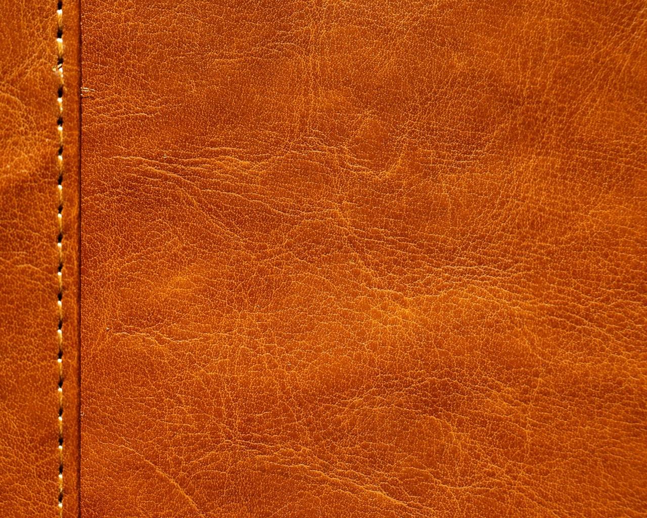 Tan leather grain crossed by a line of stitching